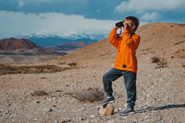 男孩游客在山上用双筒望远镜看 — 图库照片