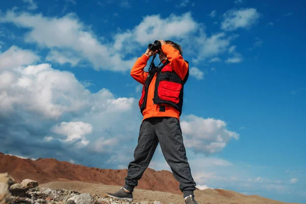 男孩游客在山上用双筒望远镜看 — 图库照片