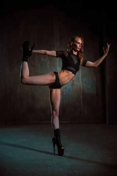 年轻性感的女舞蹈演员在黑暗的墙壁背景下表演 — 图库照片