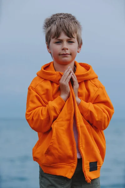 折り畳まれた腕を持つ湖畔に立つ少年の肖像 — ストック写真