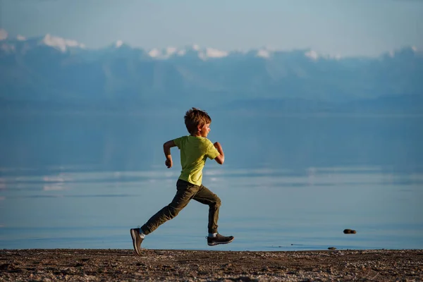 湖の岸 イシクル湖 キルギスタンに沿って走る少年 — ストック写真