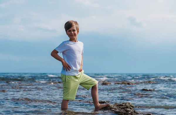 一个快乐的七岁男孩站在海边的画像 — 图库照片