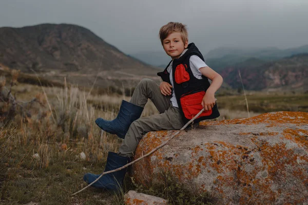 Boy Hiker Stick Vest Rubber Boots Sitting Stone Mountains — Stock Photo, Image