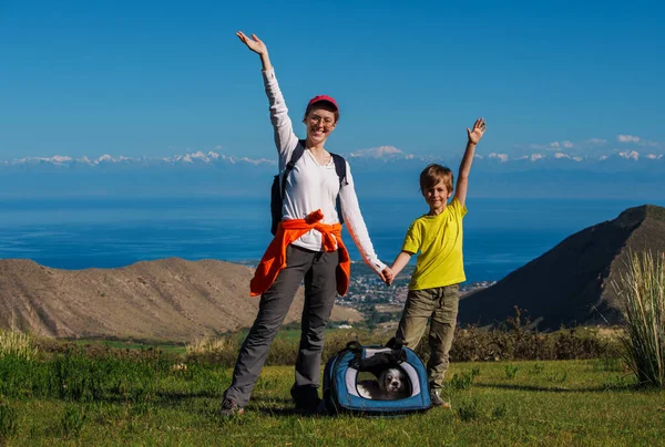 快乐的徒步旅行妈妈和儿子带着狗爬上山顶 — 图库照片