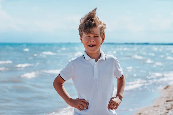 風の強い日の海辺で笑う少年の肖像 — ストック写真