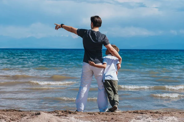 Πατέρας Και Γιος Αγκαλιάζονται Στην Όχθη Της Λίμνης Και Κοιτάζουν — Φωτογραφία Αρχείου
