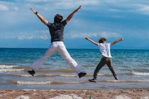 Szczęśliwy Ojciec Syn Skaczący Brzeg Jeziora — Zdjęcie stockowe