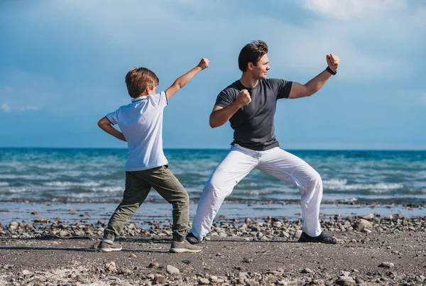 Батько Вчить Свого Сина Бойовим Мистецтвам Пляжі — стокове фото