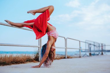 Güzel genç bayan dansçı gezinti güvertesinde geriniyor.