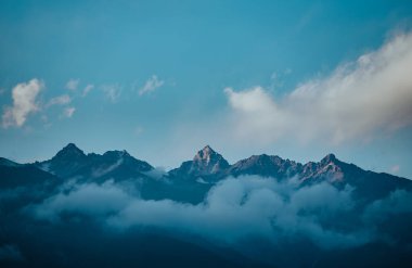 Alacakaranlıktaki bulutlar ve dağların dramatik manzarası