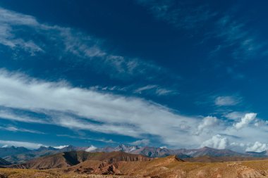 Dağ zirveleri ve mavi gökyüzü olan resim gibi bir manzara.