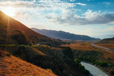 Gün batımında nehir ve karayolu ile resimli dağ manzarası