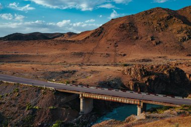 Kırgızistan 'da dağların üzerinden geçen yol köprüsü