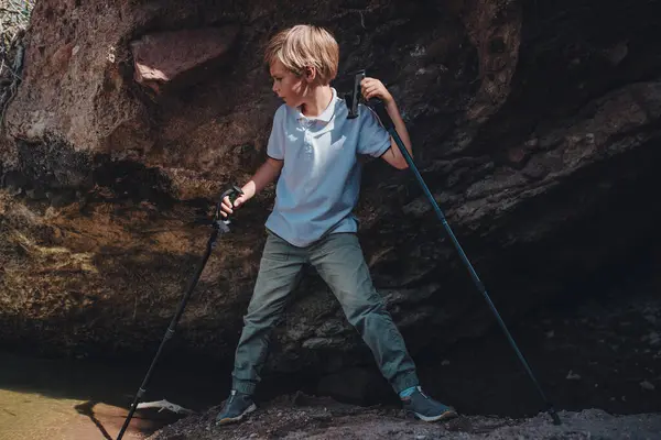 Chłopiec Wędrowiec Kijkami Trekkingowymi Stoi Jaskini — Zdjęcie stockowe