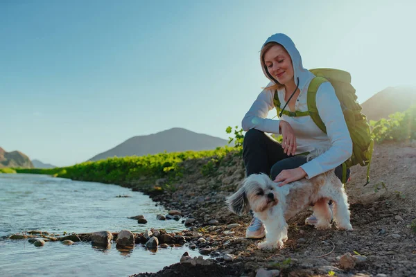 サンセットライトで湖岸のシュトゥズ犬と若い女性観光客 — ストック写真