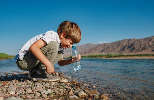 Rapaz Olhar Para Garrafa Água Extraída Rio Montanha — Fotografia de Stock