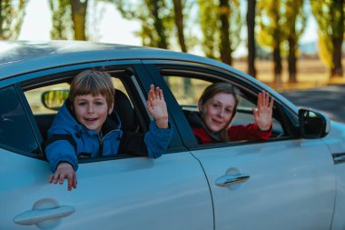 Mutlu anne ve oğul araba camından el sallıyor.