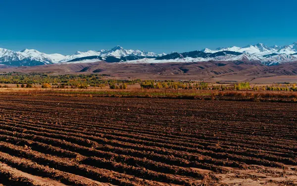 山の背景に耕起フィールドと秋の風景 キルギス — ストック写真
