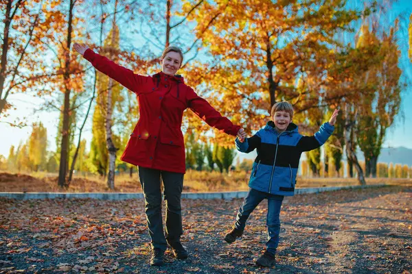 Szczęśliwa Młoda Kobieta Synem Trzymającym Się Ręce Jesiennym Parku — Zdjęcie stockowe