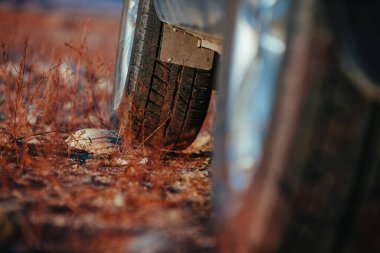 Otomobil tekerleği taşın yakın görüntüsünde duruyor.