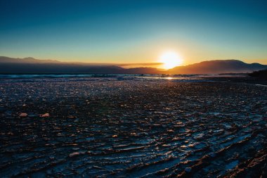 Soğuk kış havasında gölde buz, günbatımı ışığı