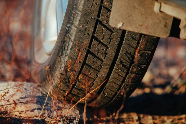 Car wheel standing on stone close-up view