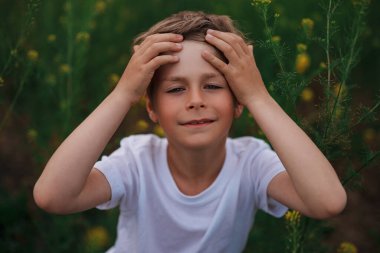 Yazın çiçek çayırında sevimli bir çocuğun portresi.