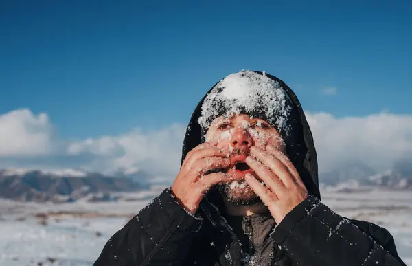Młody Człowiek Dotyka Swojej Twarzy Śniegiem Tle Gór Zimie — Zdjęcie stockowe