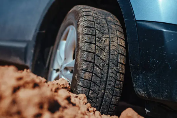 Car tire stuck in the mud close-up view