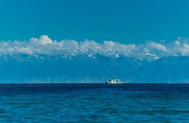 Issyk-Kul Gölü 'nde gemi ve yaz mevsiminde yüksek Tien-Shan dağları, Kırgızistan
