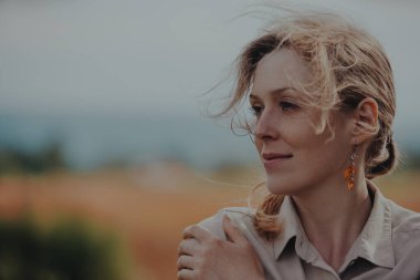 Rüzgarda dalgalanan saçları olan güzel genç bir kadının romantik portresi.