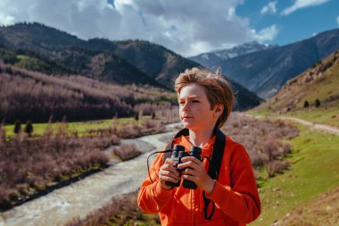 Dağlarda dürbünlü erkek turistin portresi
