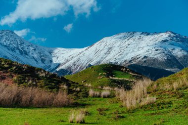 İlkbaharda kar zirveleri olan resimli dağ vadisi