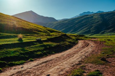 Gün batımında toprak yolu olan pitoresk dağ vadisi