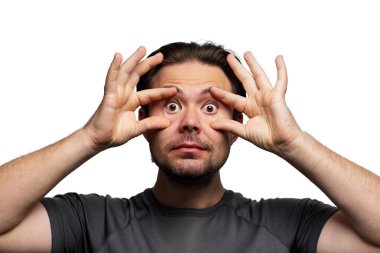 Gözlerini kocaman açan bir adam, beyaz arka planda izole edilmiş bir portre.