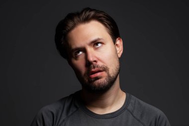 Karanlık arka planda genç yorgun adam portresi