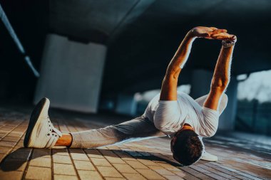 Alacakaranlıkta şehir arka planında poz veren güçlü adam