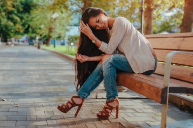 Yaz kenti caddesinde bankta oturan genç ve güzel bir kadın