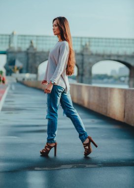 Genç moda kadını yaz günü şehir caddesinde yürüyor.