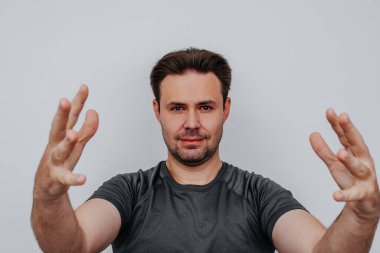 Genç adam beyaz arka planda büyük bir el yazısı portresi tutuyor.