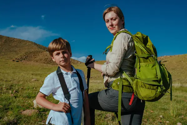 Çocuk turist ve annesi dağ portresiyle seyahat ediyorlar.
