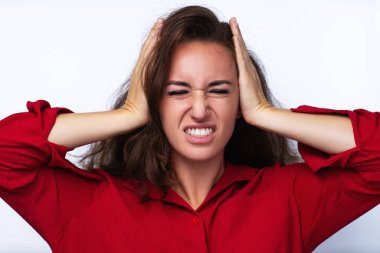 Genç bir kadın, beyaz arka planda duygusal portre takıyor.