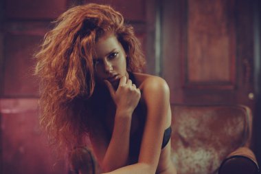 Genç kızıl saçlı kadın iç mekan portresi düşünüyor.