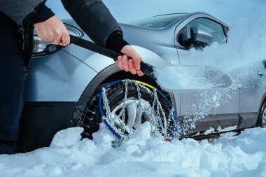 Adam, kış günü derin karda kürek arabasıyla kazar.