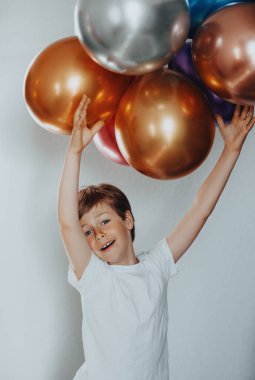 Kafasının üstünde balon tutan yakışıklı bir çocuğun portresi.