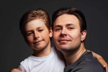 Baba oğul koyu arkaplanda sevimli bir portre.