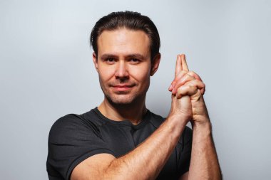 Parmak izi gösteren yakışıklı bir adam, beyaz arka planda portre.