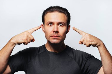 Ciddi bir adam gözlerini işaret ediyor, göz konseptime bak, beyaz arka planda portre.