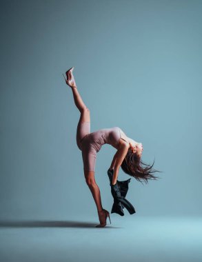 Genç bayan jimnastikçi stüdyoda dans ediyor.