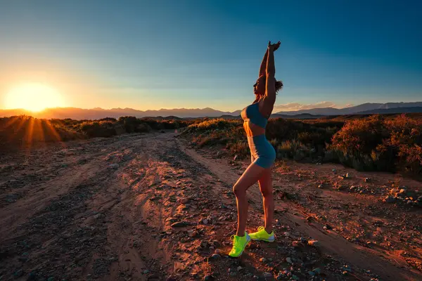 Slim fitness kadını yaz günü gün batımının ılık ışığında antrenman yapıyor.